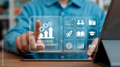 Businessman touching a tablet screen showing process improvement icons representing business growth and key performance indicators