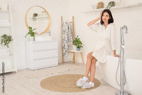 Thoughtful young woman in b...