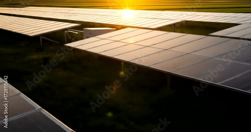 Aerial View of Solar Panel Farm at Golden Hour, Reflecting Sunlight on Array Surface for Clean