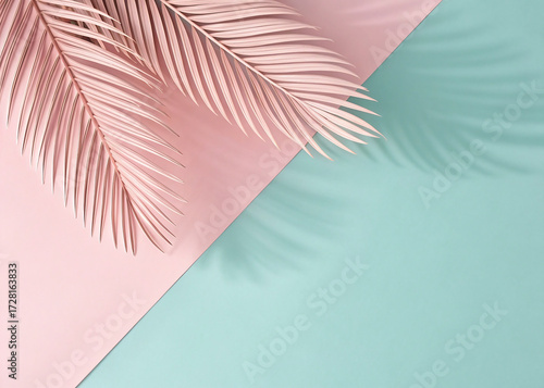 Pink palm leaves casting shadows on pink and teal background