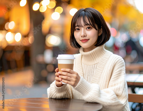 カフェテラスでくつろぐ若い女性/Young woman relaxing on a cafe terrace