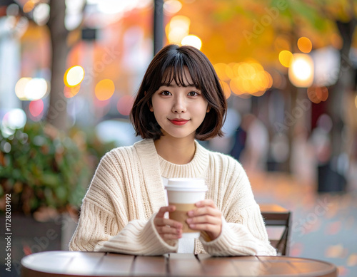 カフェテラスでくつろぐ若い女性/Young woman relaxing on a cafe terrace