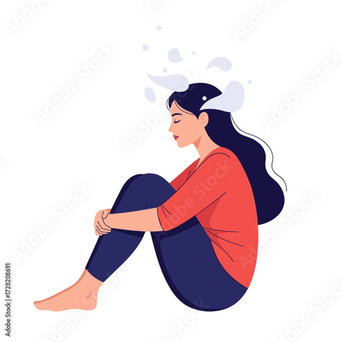 Young woman sitting with her knees pulled up to her chest in a state of contemplation.