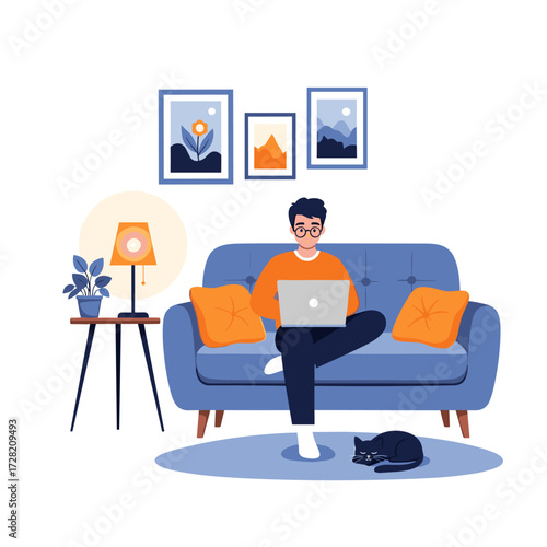 A young man working on his laptop on a comfortable blue sofa at home.