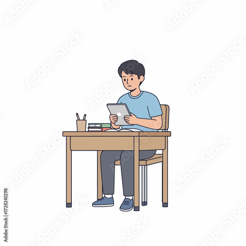 A male student sits at his desk, studying or learning online using a digital tablet for his education.