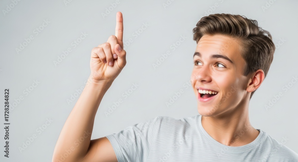 Naklejka premium Excited Teenage Boy Pointing Upward with a Creative Idea, Isolated on White Background