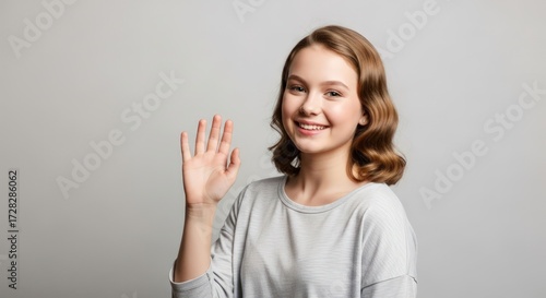 Wallpaper Mural Smiling Teenage Girl Waving Hello on Gray Background Torontodigital.ca
