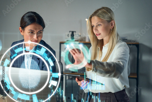 Business Women Analyzing High Tech Security Interface With Holographic Data Visualization In Modern Office