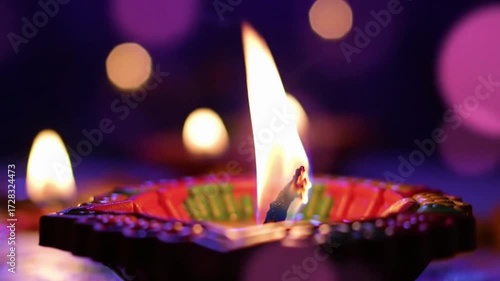 Closeup of a lit diya with bokeh lights 2.