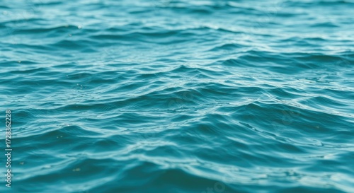 Serene turquoise ocean water with gentle ripples reflecting sunlight, perfect for summer vacation, relaxation, and nature themes