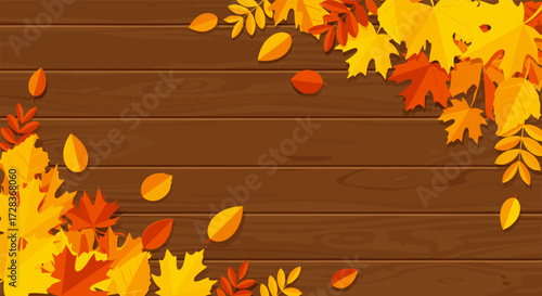 Vibrant autumn fall leaves frame a rustic wooden background with ample copy space for seasonal designs and festive greetings