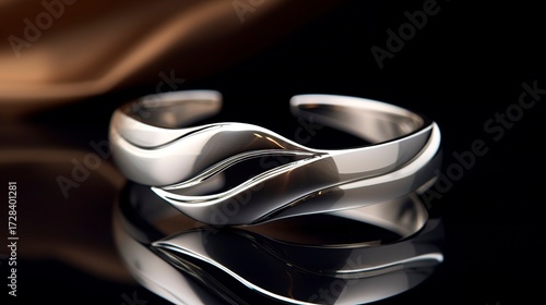 A photo of a sleek silver open cuff.