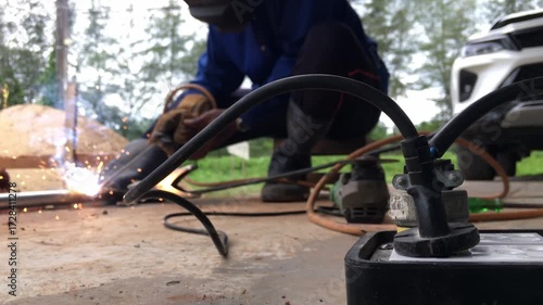 Man welding steel, blurred on black background
