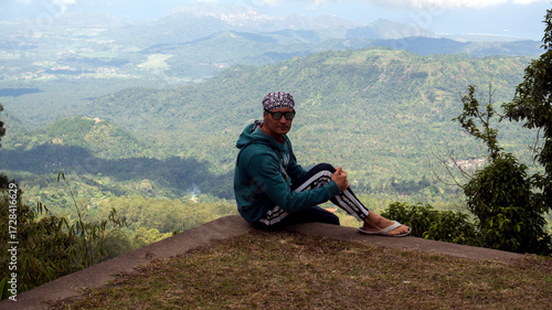 The guy stands against the background of a tropical forest. Adventures in Southeast Asia