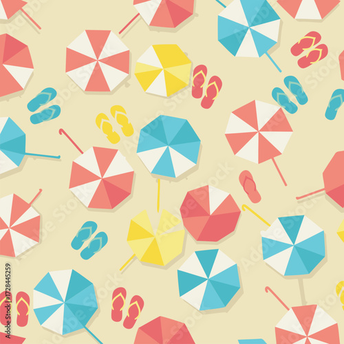 Beach umbrellas and flip-flops on a sandy beach. Overhead view of colorful beach umbrellas and flip-flops arranged on a sandy background. Vacationer-focused beach scene -