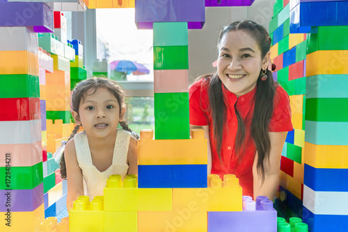 Mother and  daughter is doing holiday activities together by connecting plastic models in various shapes.