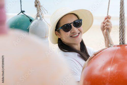 Cute female tourists are smiling to take pictures to relax by the sea.