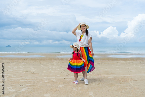 Asia and the Asian daughter are posing to take pictures of the atmosphere by the sea.