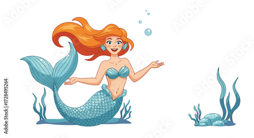 A joyful red haired mermaid swims in the clear ocean water surrounded by seaweed and rocks.