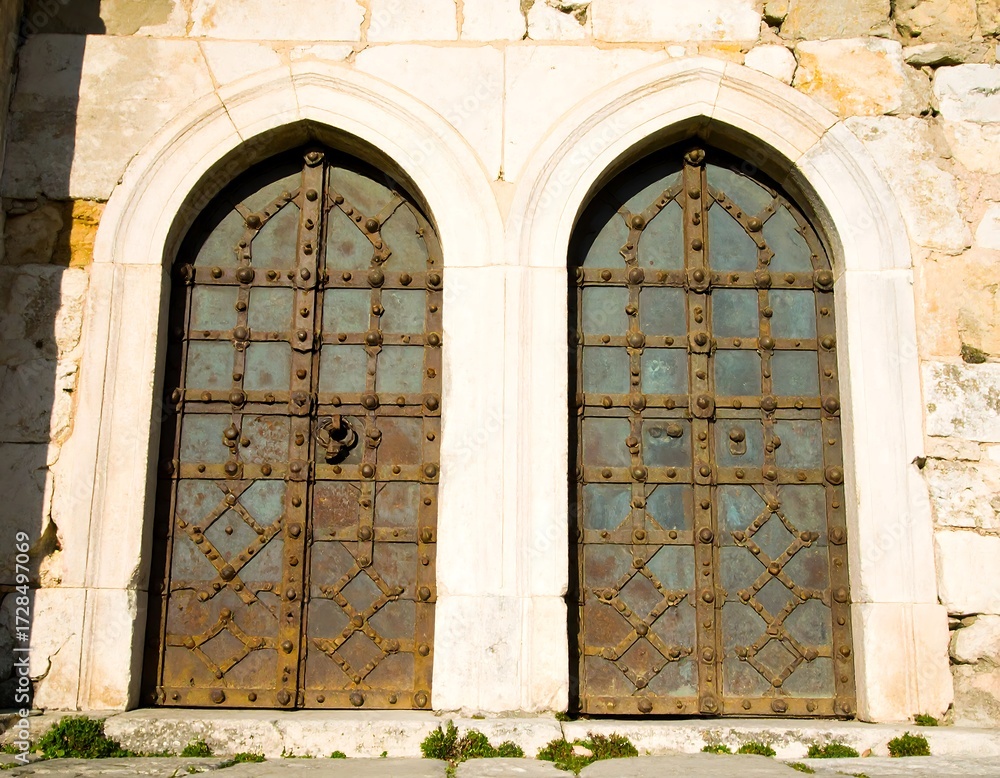 Obraz premium Two ancient arched doors in a stone wall