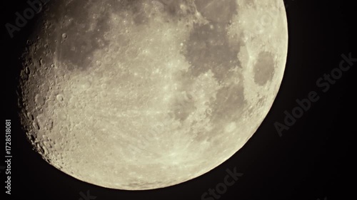 Close-up of the Moon with visible craters, dark volcanic spots and traces of eruptions. Earth's satellite observed through a telescope. Astronomy and planets in the starry night sky.