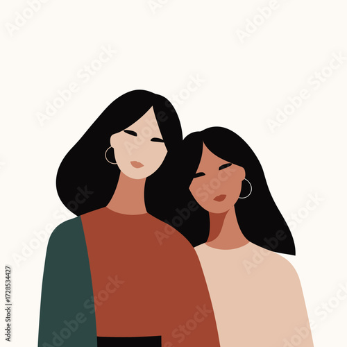Two women are standing side by side with soft smiles. They have long hair and wear simple, stylish outfits. Their friendly posture suggests a strong bond.
