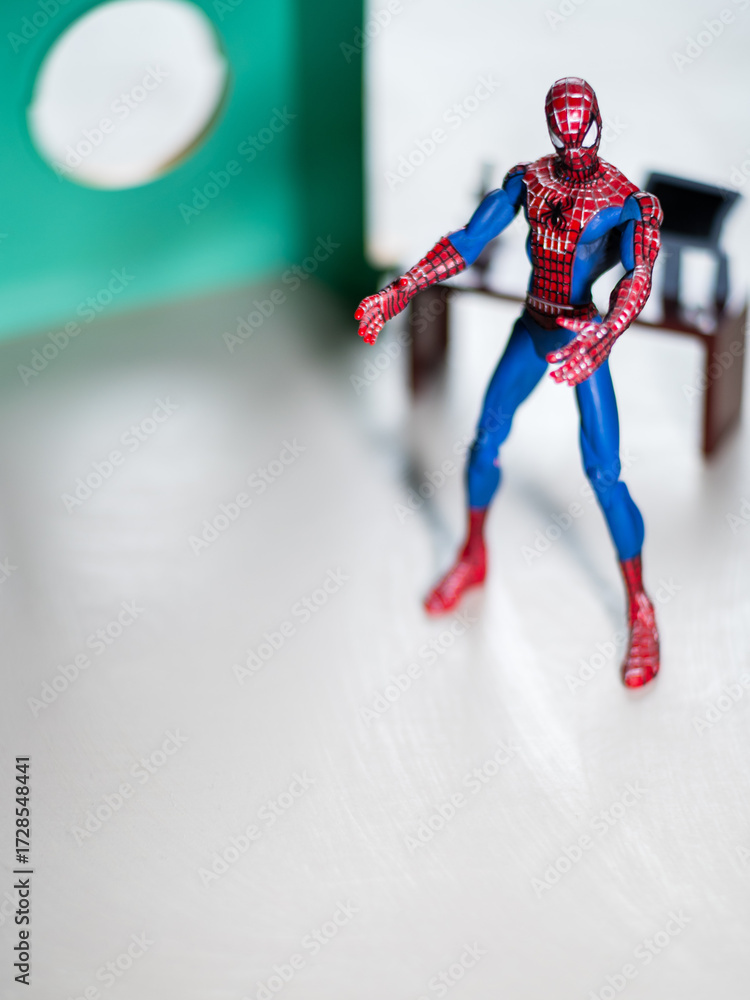 Naklejka premium Spider Man figure in his office with desktop and Computer.