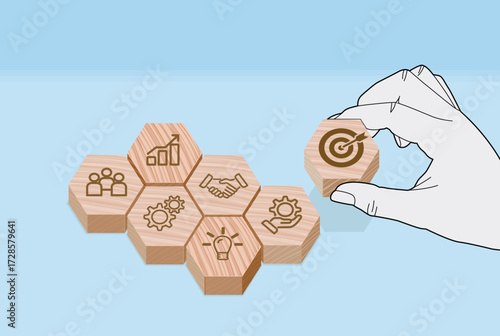 Strategic Goal Setting with Business Icon Blocks, Hand places target icon atop visual framework of business concepts