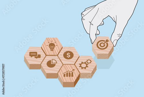 Strategic Goal Setting with Business Icon Blocks, Hand places target icon atop visual framework of business concepts