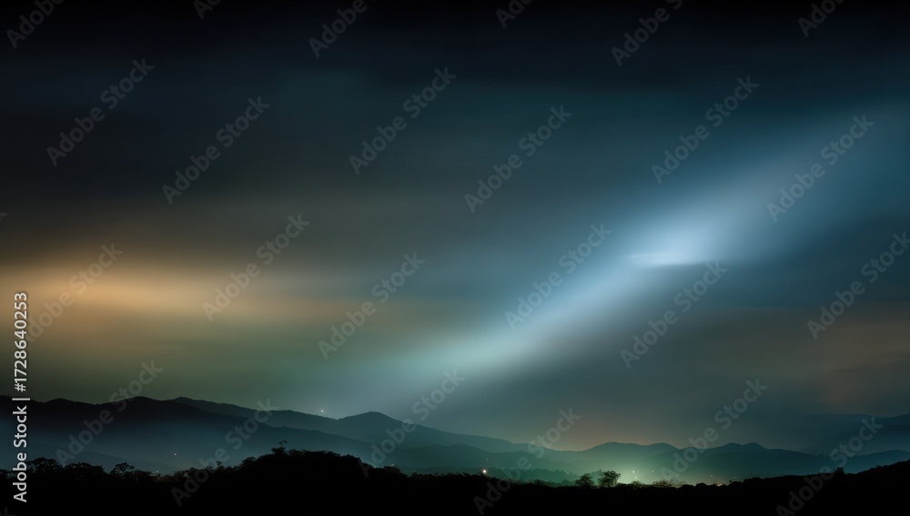 Fototapeta premium Mountain silhouettes bathed in ethereal, pale light at night, creating a tranquil and mysterious landscape.