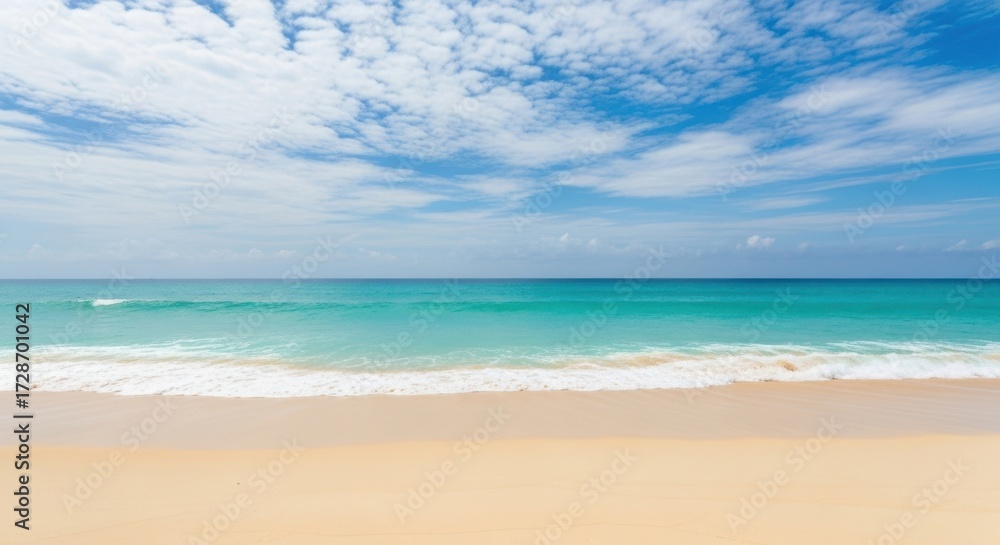 Obraz premium Serene tropical beach with turquoise water and wispy clouds on a sunny day