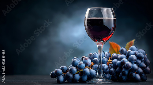 Glass of Red Wine and Dark Grapes on a Moody, Elegant Background