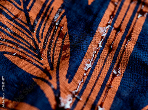 Close up of water droplets on a textured fabric with an abstract pattern.