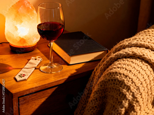 Cozy Nightstand Scene with Wine Book and Salt Lamp.