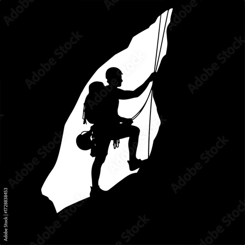 Silhouette of a man rock climbing against a cave opening in a natural setting