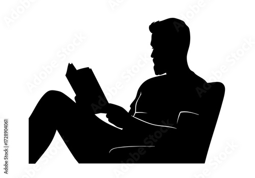 A man absorbed in reading a book, relaxed in an armchair.