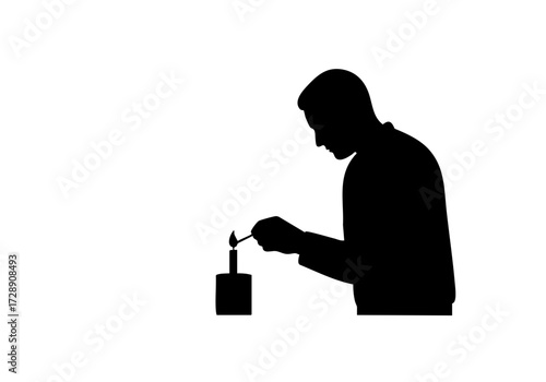 Silhouette of a person lighting a candle.