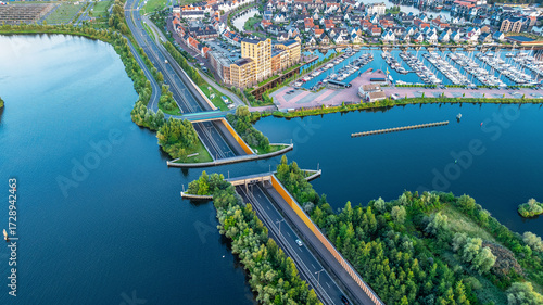 Drone view of city with road across canal, creating unique underwater bridge. Aqueduct, Netherlands.