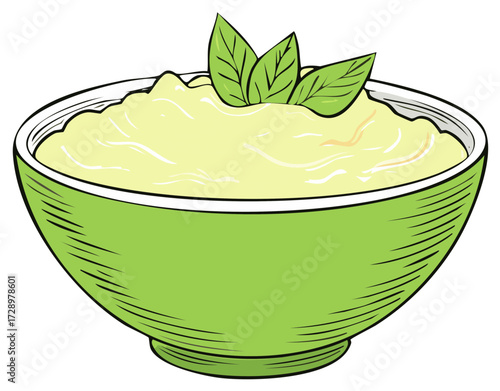 Green bowl of creamy light yellow food with fresh green leaves on top