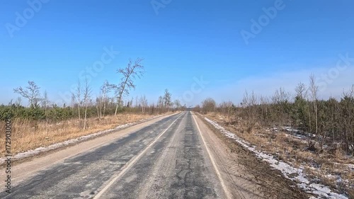 Winter road with snow, highway with cars on a sunny winter day. Winter landscape, road and shoulder covered with snow.