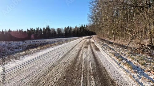 Winter road with snow, highway with cars on a sunny winter day. Winter landscape, road and shoulder covered with snow.