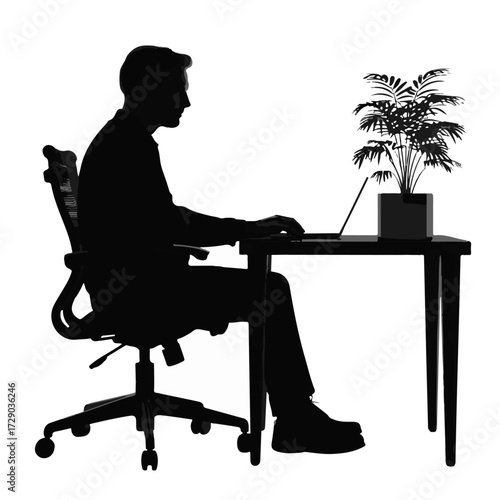 Silhouette of a man working on a laptop at a desk with a potted plant, symbolizing productivity and focus in a modern workspace environment