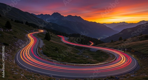 Winding road at sunset with light trails through mountain scenery