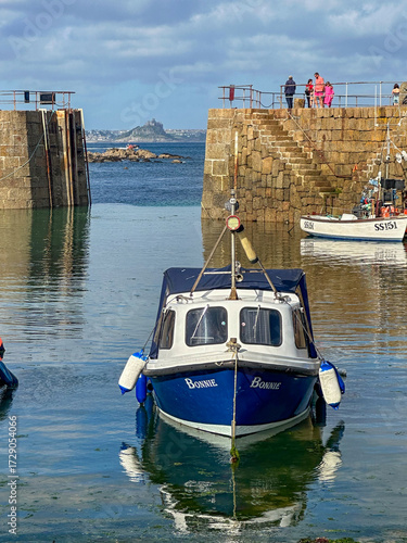 Boat in the harbour of Mousehole, Cornwall, England, with St Michaels Mount in the background.