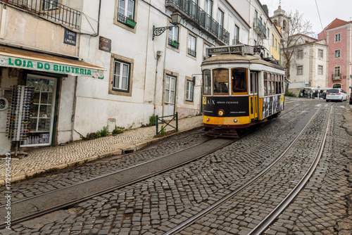 Historical Tram of the famous line 28 in the narrow alleys of the old town of Lisbon, Portugal.