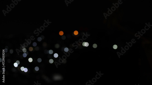 Blurred city lights sparkle in the dark night sky, creating a dreamy and abstract urban landscape with a sense of mystery and wonder.