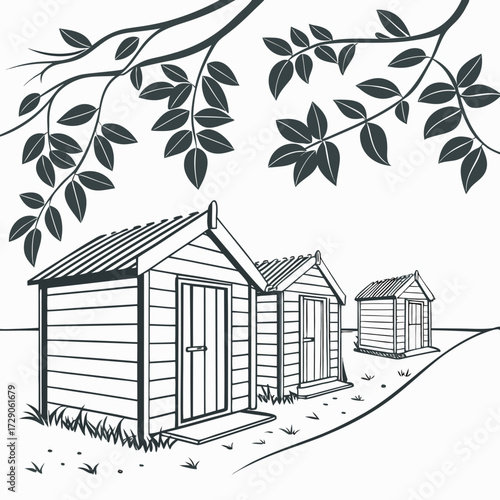 Three wooden beach huts lined up on a grassy slope under a leafy tree branch