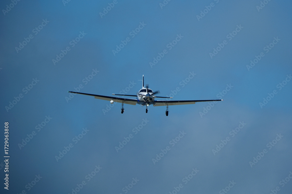 Fototapeta premium Small propeller airplane flying in the blue sky on a sunny day. Single Engine Turboprop Aircraft Landing