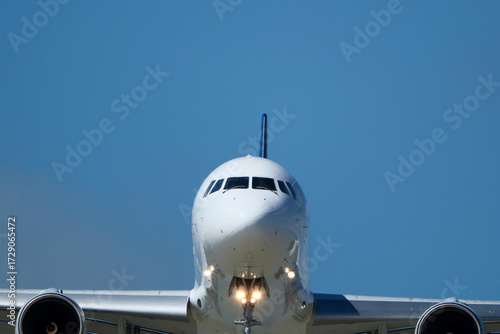 Clear Blue Sky and Aircraft Nose. Close-Up of Passenger Jet Nose and Cockpit Windows. 