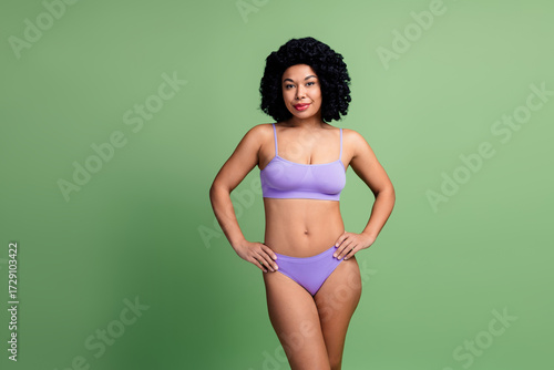 Photos Attractive young woman in purple underwear posing against vibrant green backgrou